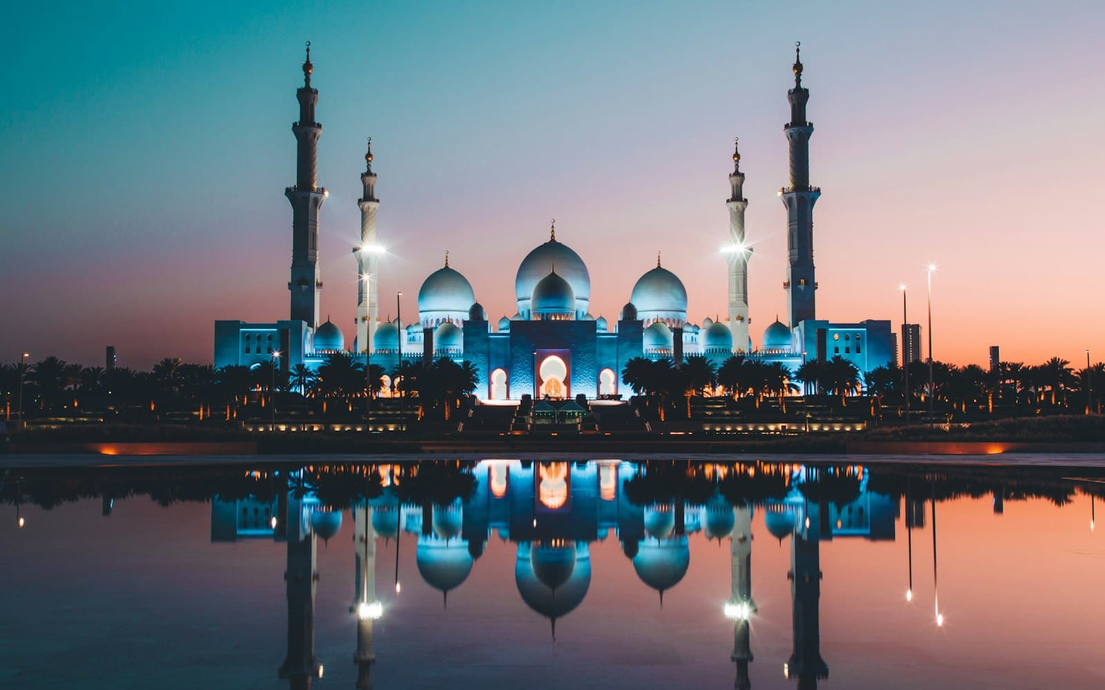 Sheikh Zayed Grand Mosque reflected in water at dusk, representing Arabic-language product audiences